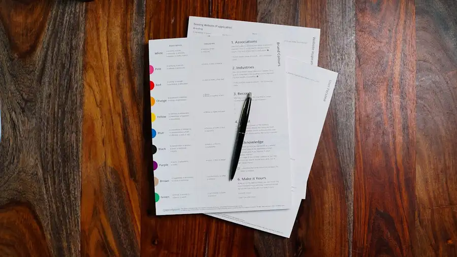 Printed statements and a pen on a wooden desk