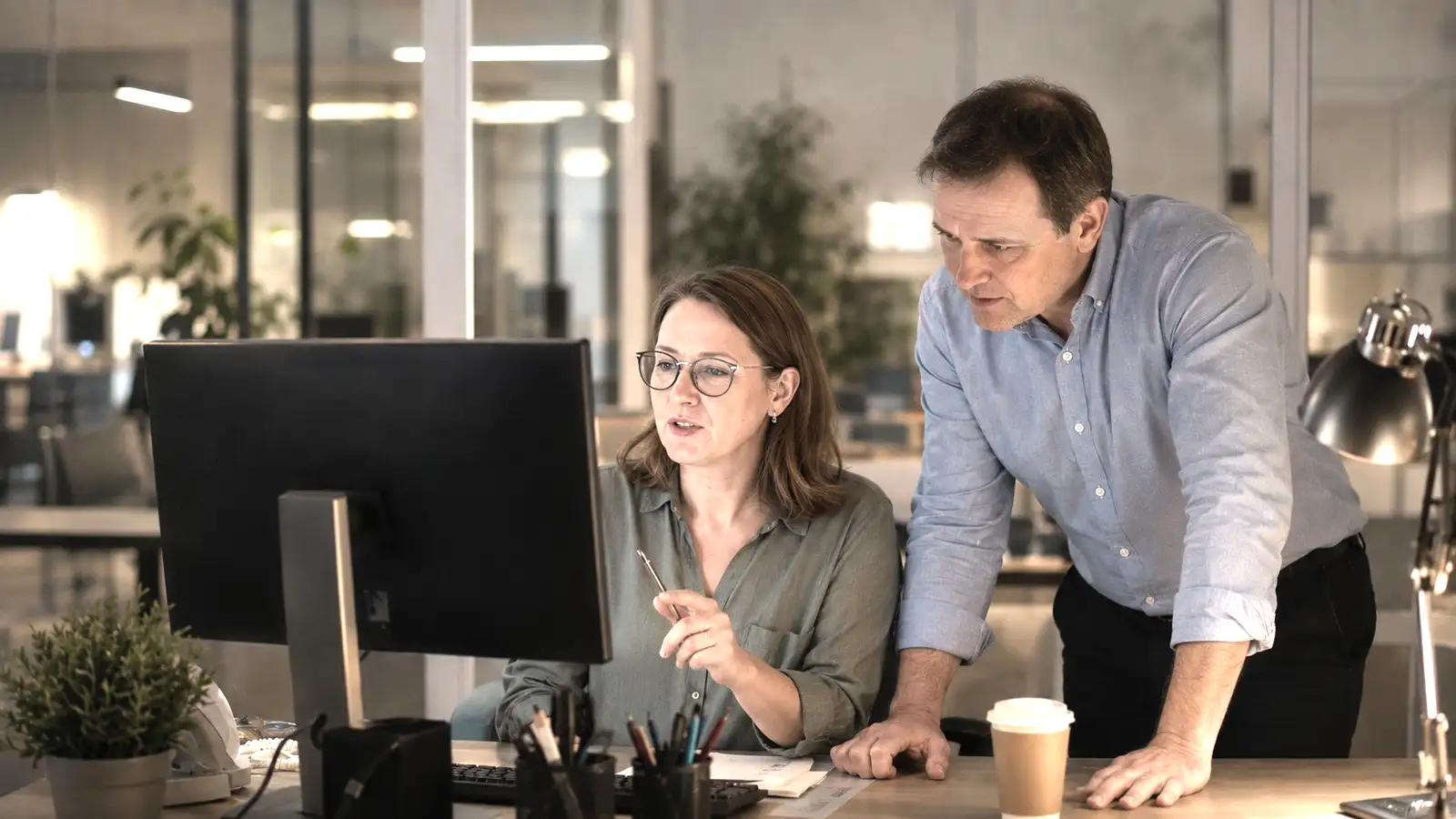 Two colleagues going through a case file in an office late in the evening