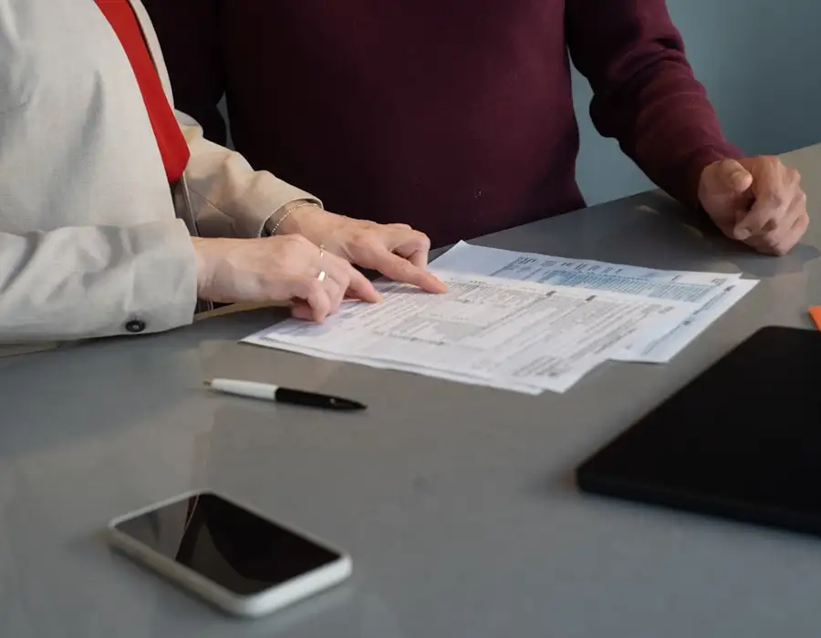 Two people going through bank statements at a desk